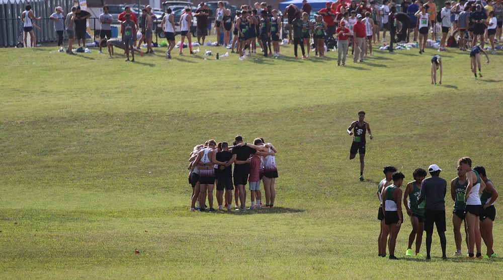Cross Country Coach praying with the team